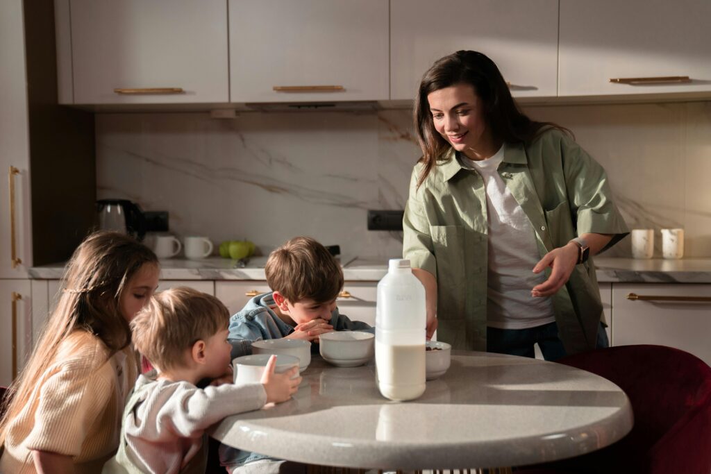 A happy family enjoying breakfast with milk and cereals in a cozy kitchen setting.